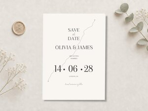 A cream-colored "Save the Date" card with a gray marathon route graphic and text "Olivia & James are getting married 14.06.28 London, UK" is on a white surface.