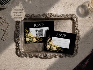 Two black RSVP cards with yellow floral accents resting on an ornate silver tray next to pearls.
