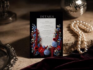 A details card for a wedding suite with red and blue flowers displayed next to pearls and a silver tray.