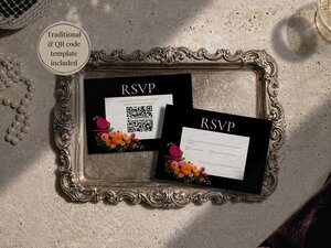 Two RSVP cards with floral accents displayed on an ornate silver tray next to pearls.