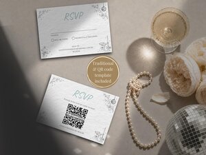 Two RSVP cards with travel-themed botanical illustrations rest on a flat surface next to a glass of champagne, a string of pearls, a disco ball, and cream-colored flowers.