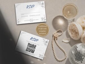 Two RSVP cards resting on a table beside a glass of champagne, a string of pearls, and white flowers.