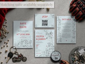 A matching suite of wedding stationery including save the dates, RSVP cards, and details cards is arranged flat with keys and a motorcycle keychain.