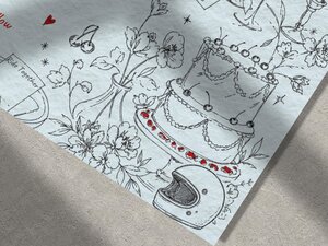 Close up of the illustrated details on the wedding invitation showing a tiered cake and a motorcycle helmet.
