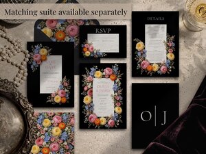 A flat lay of a complete wedding invitation suite on a black background decorated with pink, yellow, and blue wildflowers.