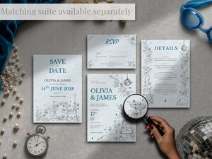 A flat lay displays a full suite of wedding stationery including save the dates, RSVP cards, and details cards, accompanied by a magnifying glass, pocket watch, and disco ball.
