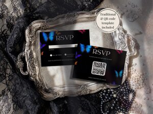 Two RSVP cards with butterfly designs resting on an ornate silver tray surrounded by lace and pearls.