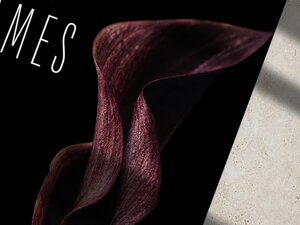 A close-up view of the dark burgundy calla lily graphic on the wedding invitation with part of the text visible.