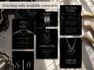 A flat lay showcasing multiple black wedding stationery items including invitations, RSVP cards, and details cards.