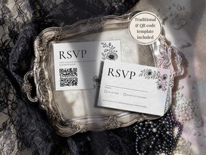 Two RSVP cards, one with a QR code, lie inside an ornate silver tray next to black lace and pearls.