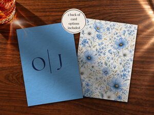 Two card options displayed side by side, one solid blue with monogram initials and the other covered in blue and white wildflowers.