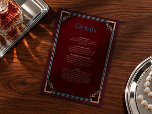 A wedding details card sits between a silver tray with a crystal decanter and a small silver dish of pearls.