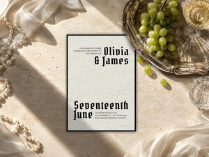 Gothic Wedding Invitation featuring a warm ivory background with a thick black border, oversized black Old English lettering and asymmetrical editorial typography; editable Canva template with refined typography and personalised wedding details.