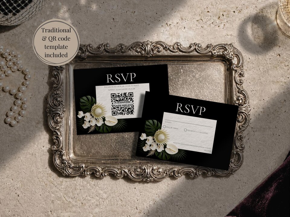 Two black RSVP cards featuring white tropical floral designs resting inside an ornate silver tray on a textured background.