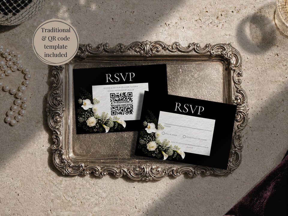 Two RSVP cards with black backgrounds and white floral arrangements resting on an ornate vintage silver tray.