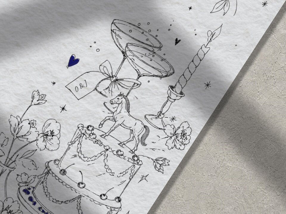 A close-up view of hand-drawn illustrations on textured paper including a wedding cake with a horse figurine, cocktail glasses, and floral elements.
