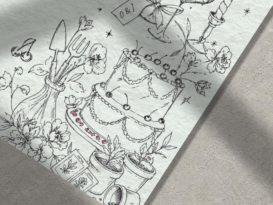 Close up view of the black ink line art illustrations on the wedding stationery showing a cake, gardening tools, and flowers.