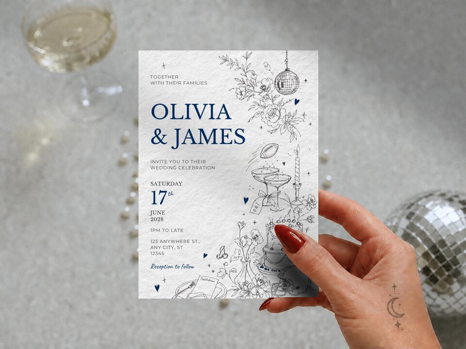 A hand holding the wedding invitation featuring blue text and whimsical line art, set against a grey background with a champagne glass and a disco ball.