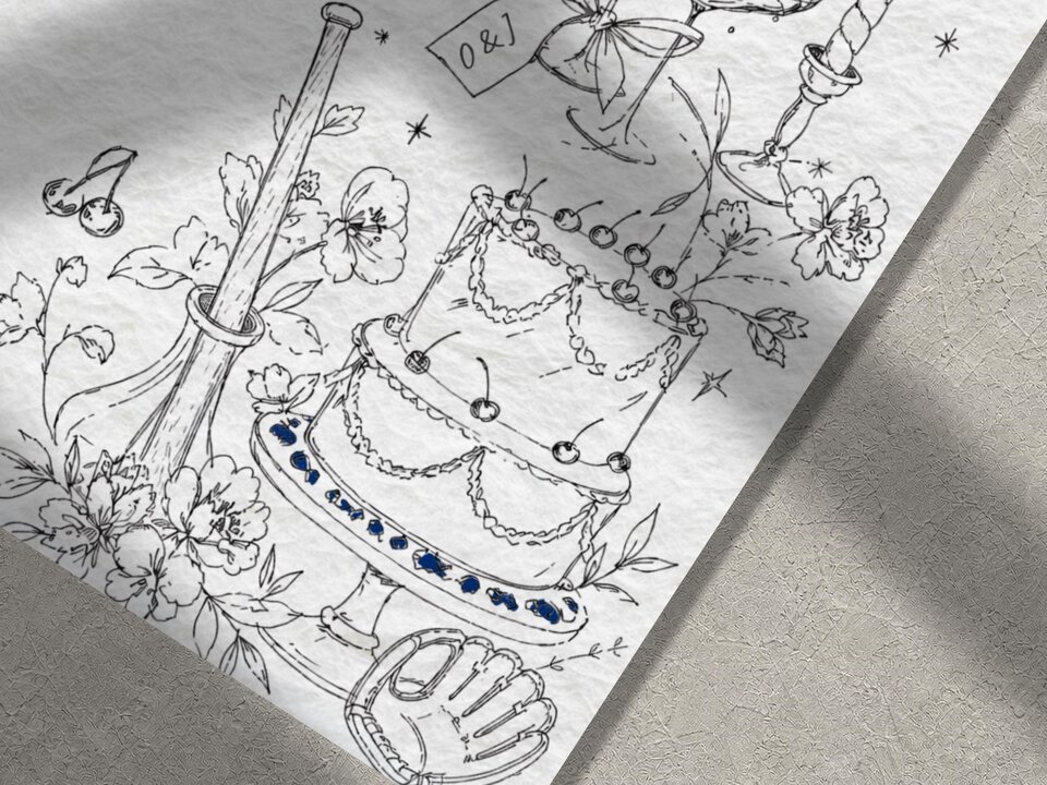 A close-up view of the illustrated wedding invitation showing a sketched tiered cake, flowers, and a baseball glove.