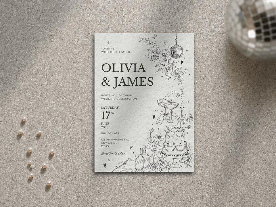 The Olivia and James wedding invitation card centered on a neutral textured surface alongside scattered pearls and a mini disco ball.