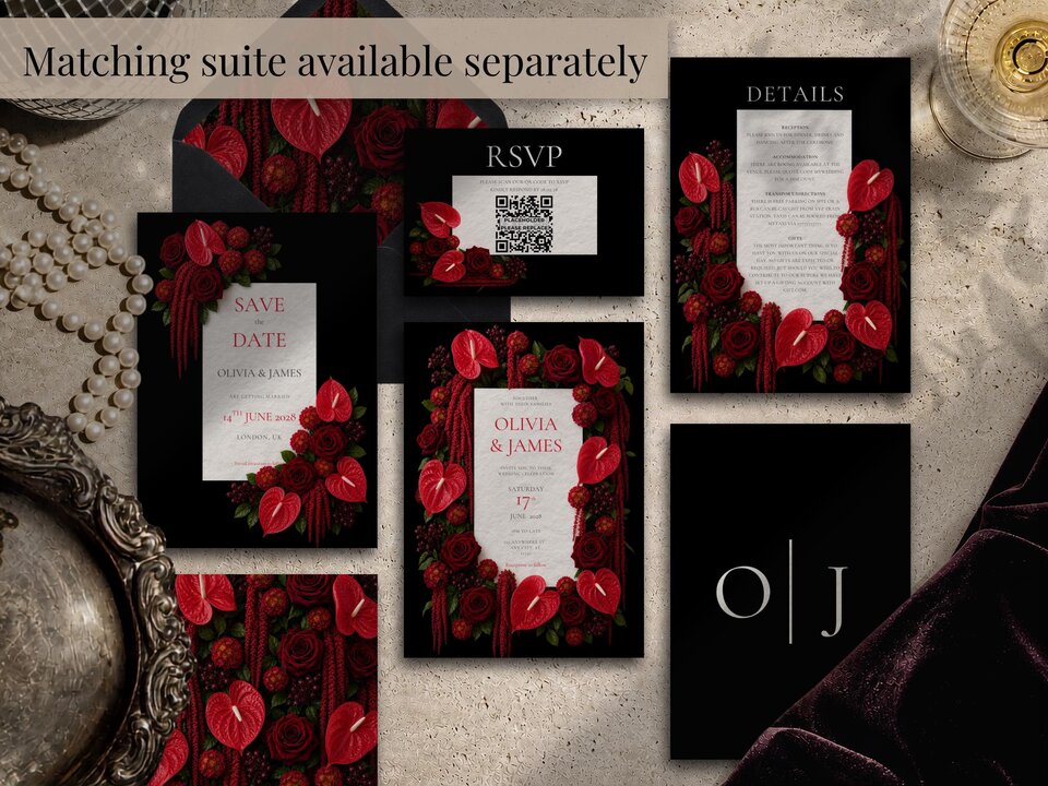 A flat lay collection of matching wedding stationery items featuring dark floral designs with red anthuriums and roses.
