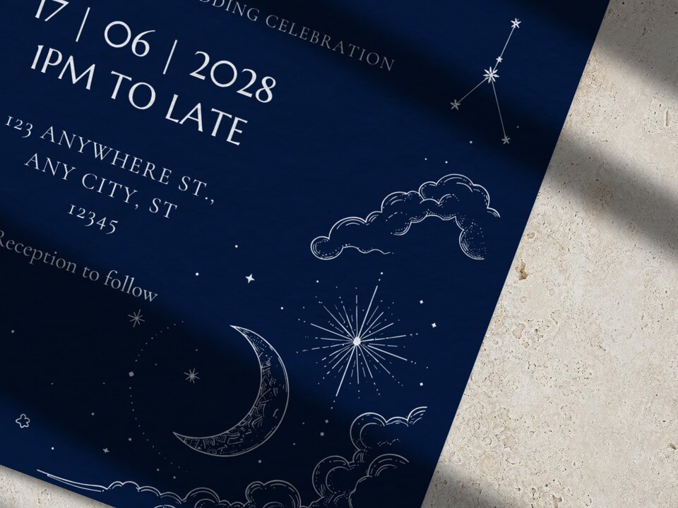 A close-up view of the lower half of a dark blue wedding invitation featuring white line illustrations of a crescent moon, stars, and clouds.