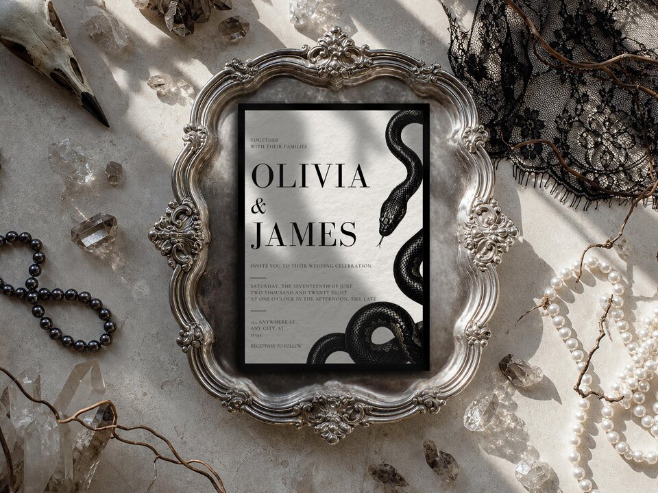 The wedding invitation rests inside an elaborate silver tray surrounded by crystal stones, pearls, and lace.