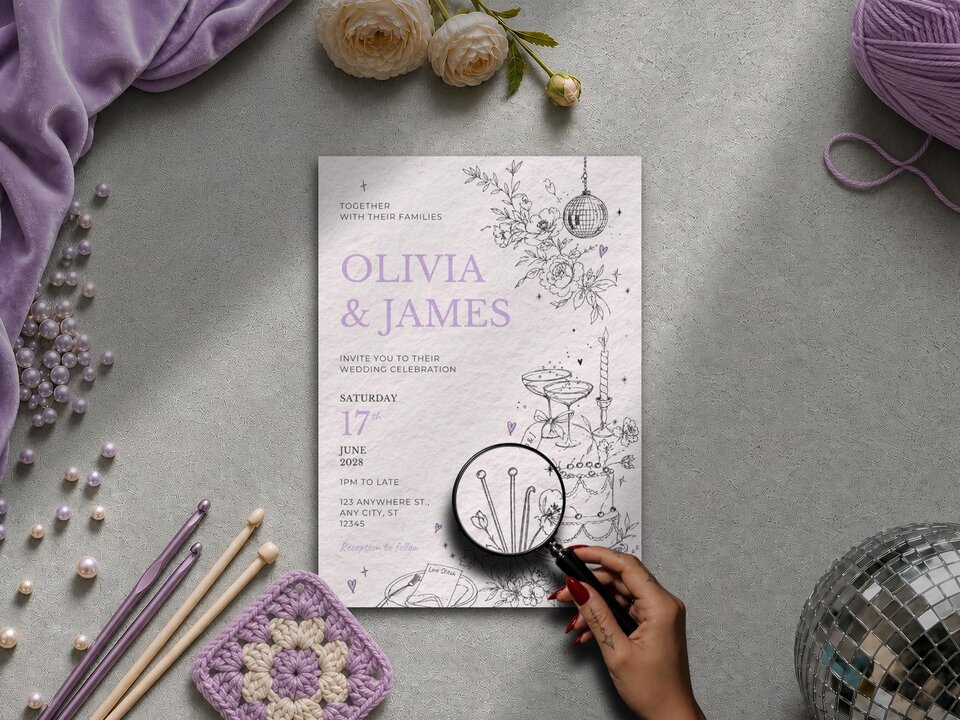 A flat lay of a wedding invitation template featuring line art and purple text for Olivia and James, surrounded by crochet hooks, yarn, and pearls.
