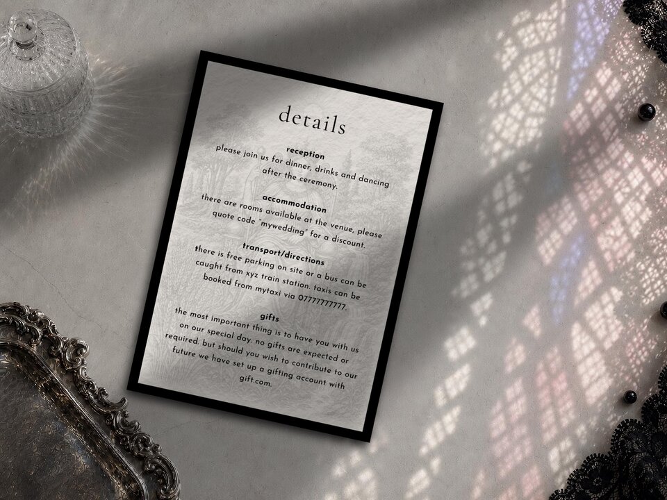 A wedding details card featuring text about reception, accommodation, transport, and gifts, laid out on a surface with decorative lace and a silver tray.