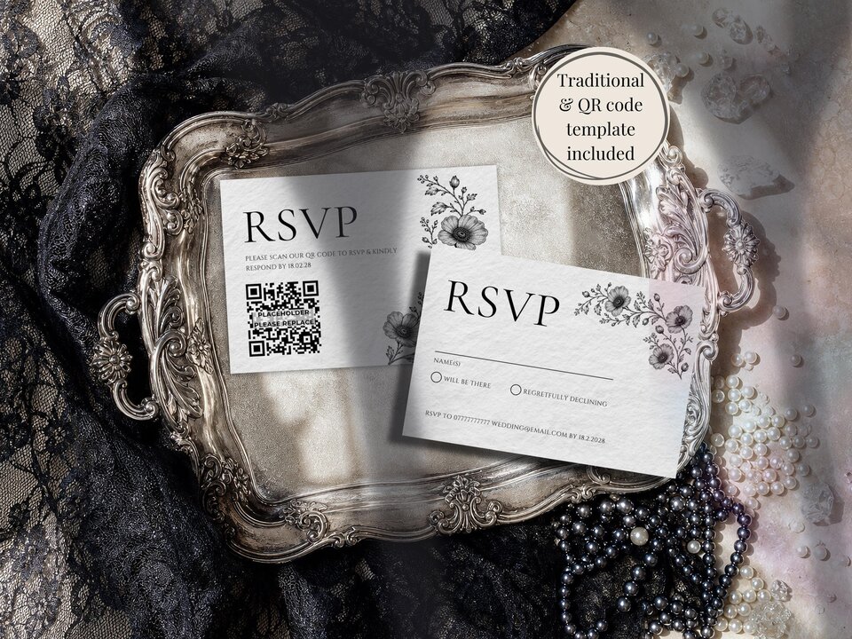 Two RSVP cards, one with a QR code, lie inside an ornate silver tray next to black lace and pearls.
