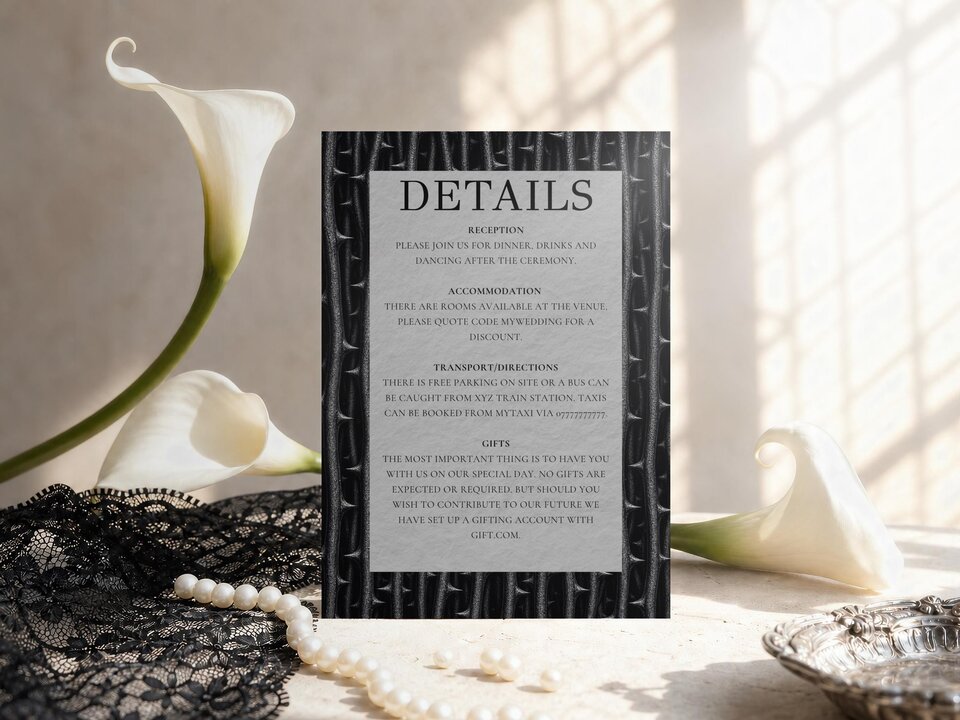 A details card is positioned between white calla lily flowers, black lace, and a string of pearls.