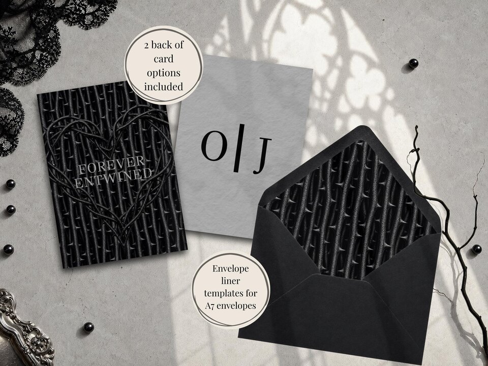 A black card with a thorny heart pattern, a gray card with monogram letters, and a black envelope with a thorny liner are arranged on a concrete surface.