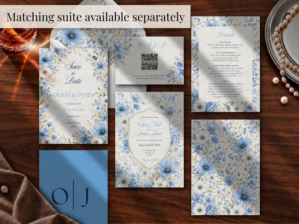 Flat lay of multiple matching wedding stationery cards featuring blue floral designs on wooden table surface.
