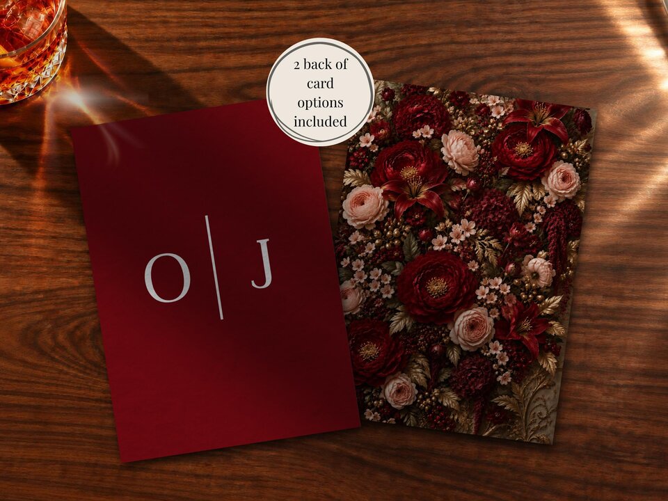 Two wedding card options displayed on a wooden table, one showing a dark red back design with initials and the other a floral front.